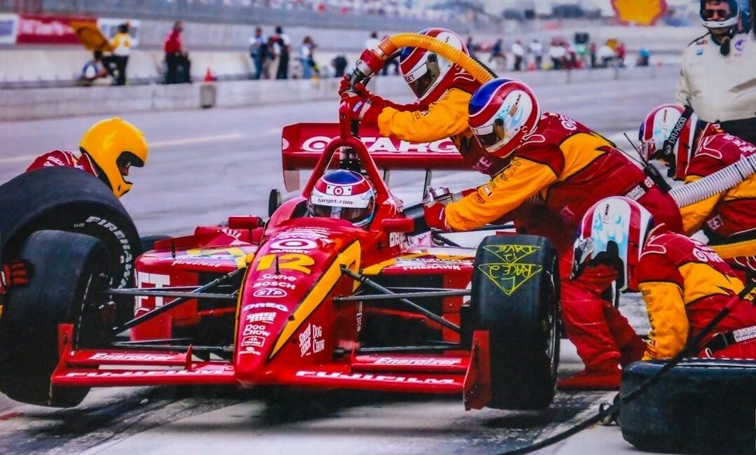 Formulewagen tijdens een snelle pitstop met meerdere monteurs