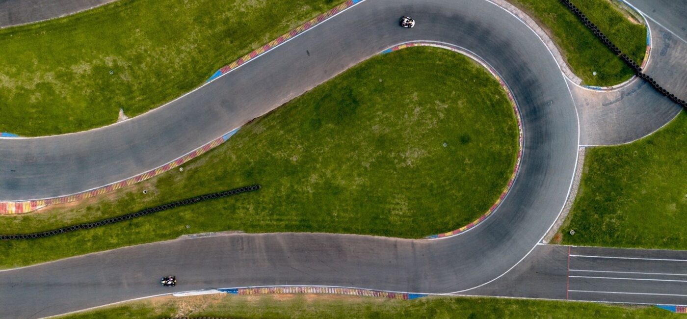 Luchtfoto van een racecircuit met krappe bochten en twee kartauto’s