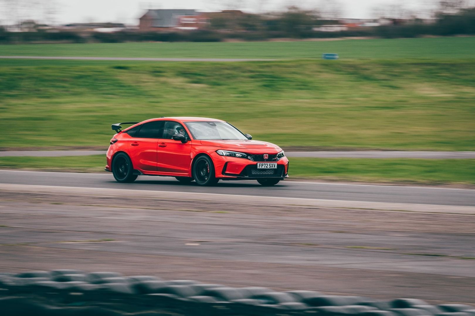 Rode Honda Civic Type R rijdt snel over een racecircuit